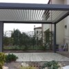 Pergola bioclimatica grigio antracite a pale orientabili con casetta integrata da giardino