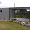 Pergola bioclimatica grigio antracite a pale orientabili con casetta integrata da giardino
