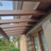 Pergotenda addossata in metallo marrone con telo teso retrattile installata su terrazzo