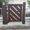 Cancelletto pedonale in metallo con intagli diagonali e colonna portalettere con videocitofono integrato